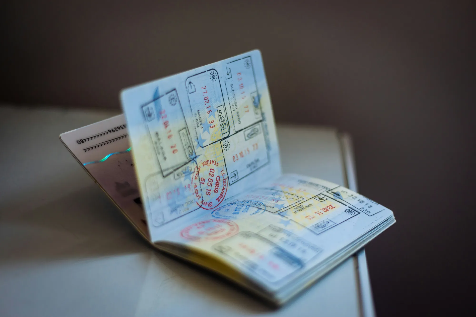 A passport, Umrah visa printout, vaccination certificate and phone showing the Nusuk app laid out for travel