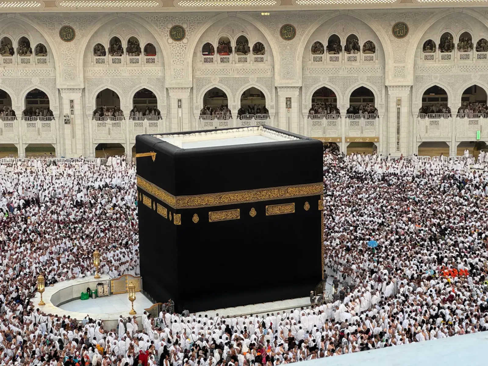 Dense crowds filling the courtyards of Masjid al-Haram at night, typical of Ramadan and peak season
